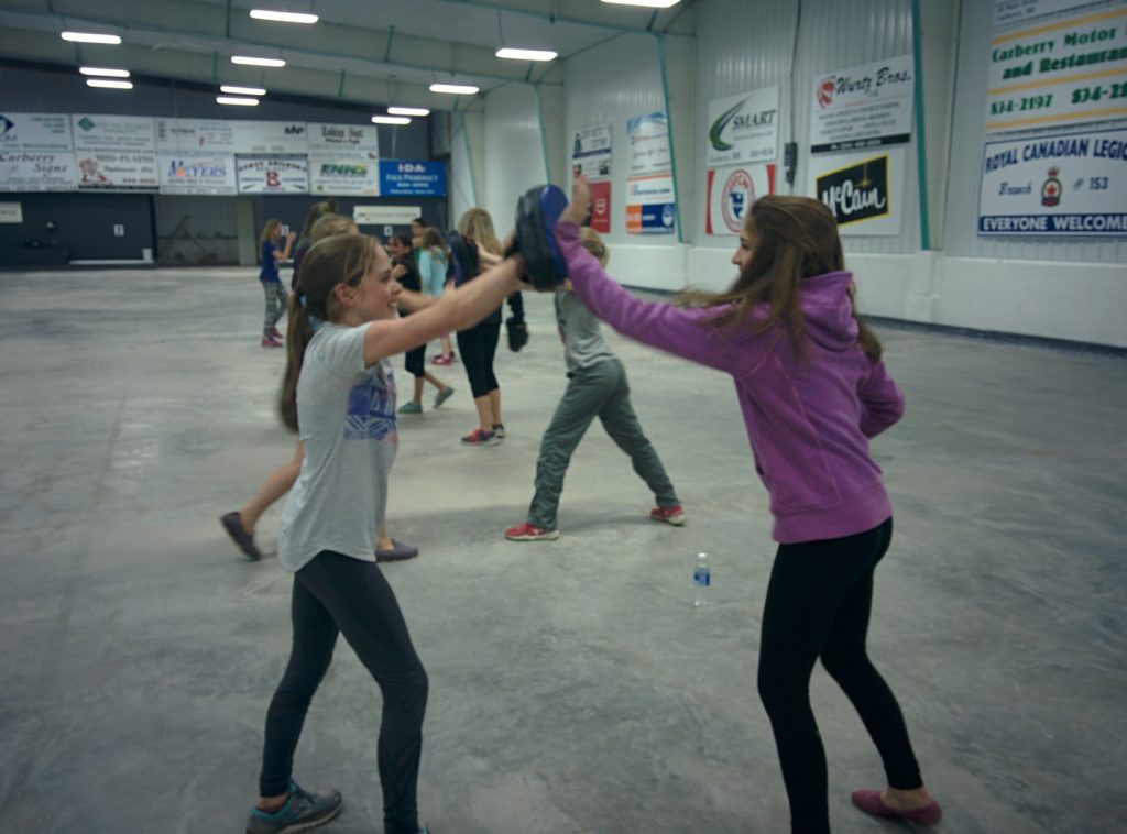 Participants practising partner drills in a self-defense seminar